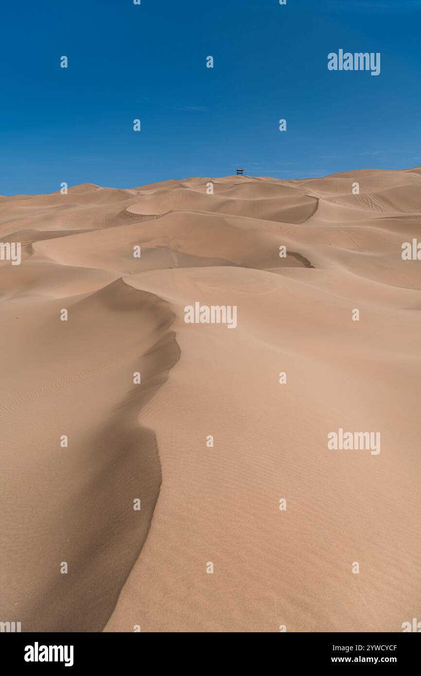 Il mare del deserto, le onde di sabbia al tramonto nel deserto di Kumtag, la città di Shanshan, Xinjiang, Cina, spazio copia per testo, sfondo Foto Stock