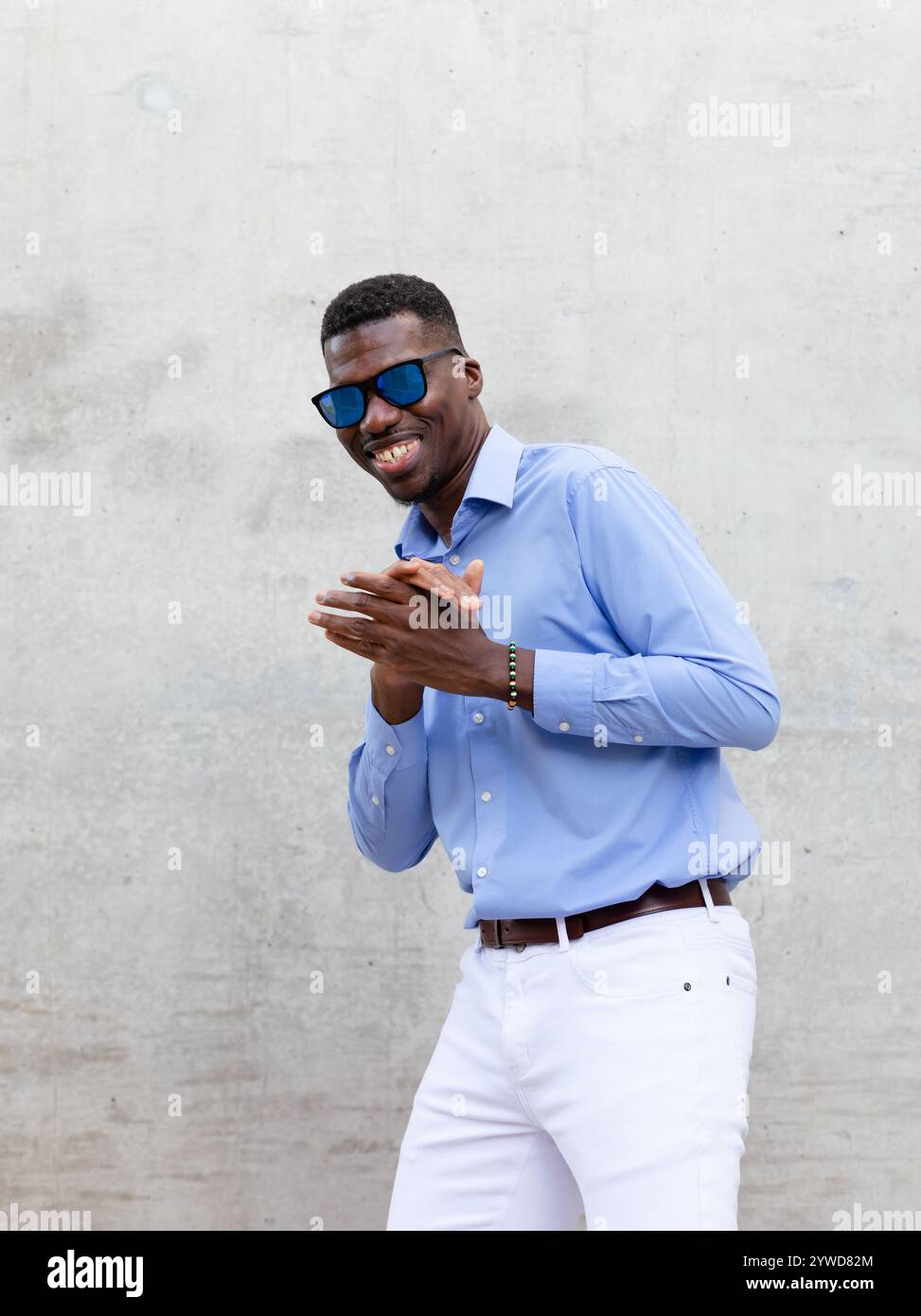 Ritratti allegro giocoso uomo afroamericano sorridente nei suoi 40 anni con occhiali da sole e camicia blu. Ritratto di un uomo felice ed elegante del Medioevo, Gray Foto Stock