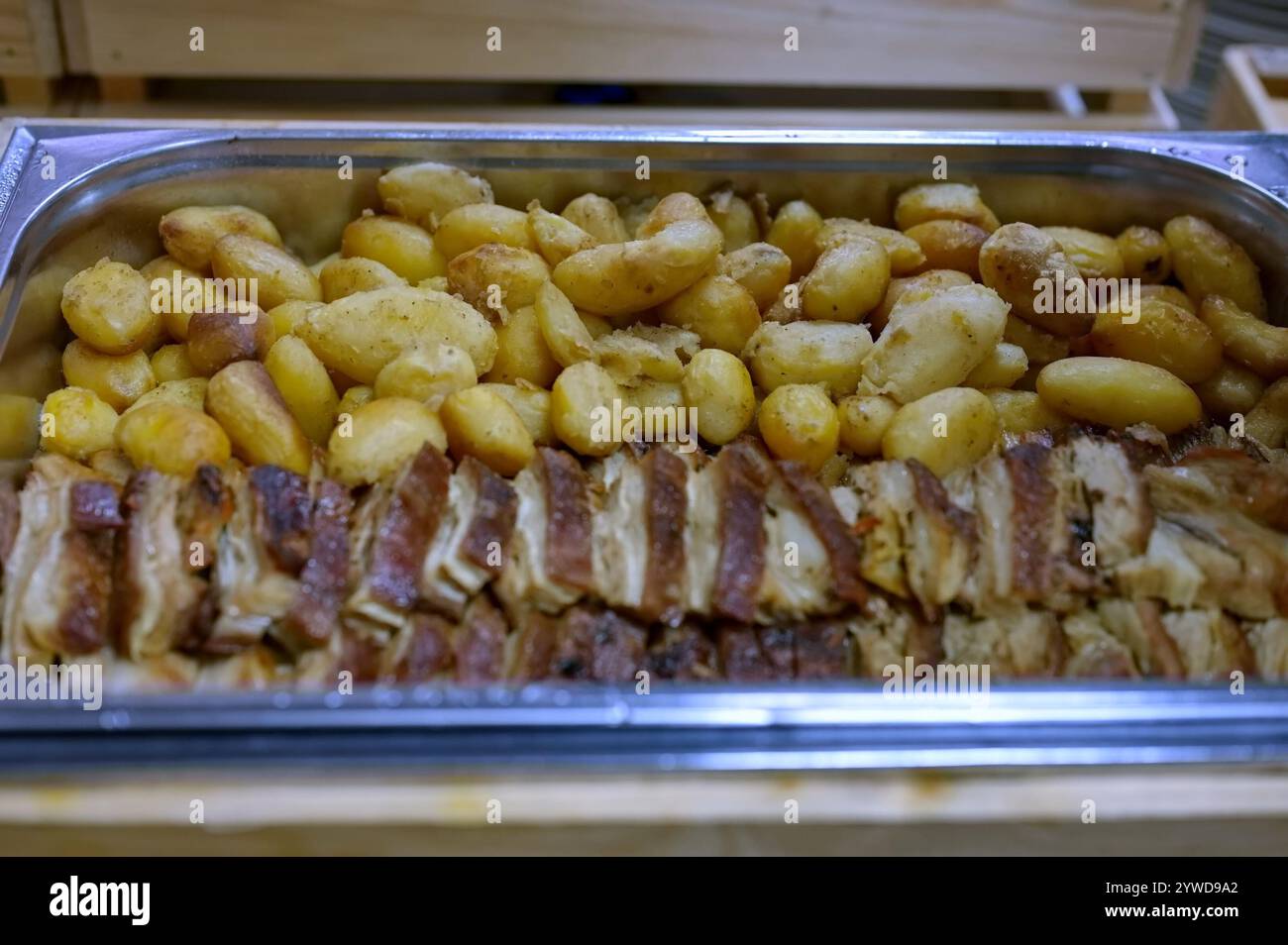 Contenitore metallico di carne di maiale cotta e patate Foto Stock