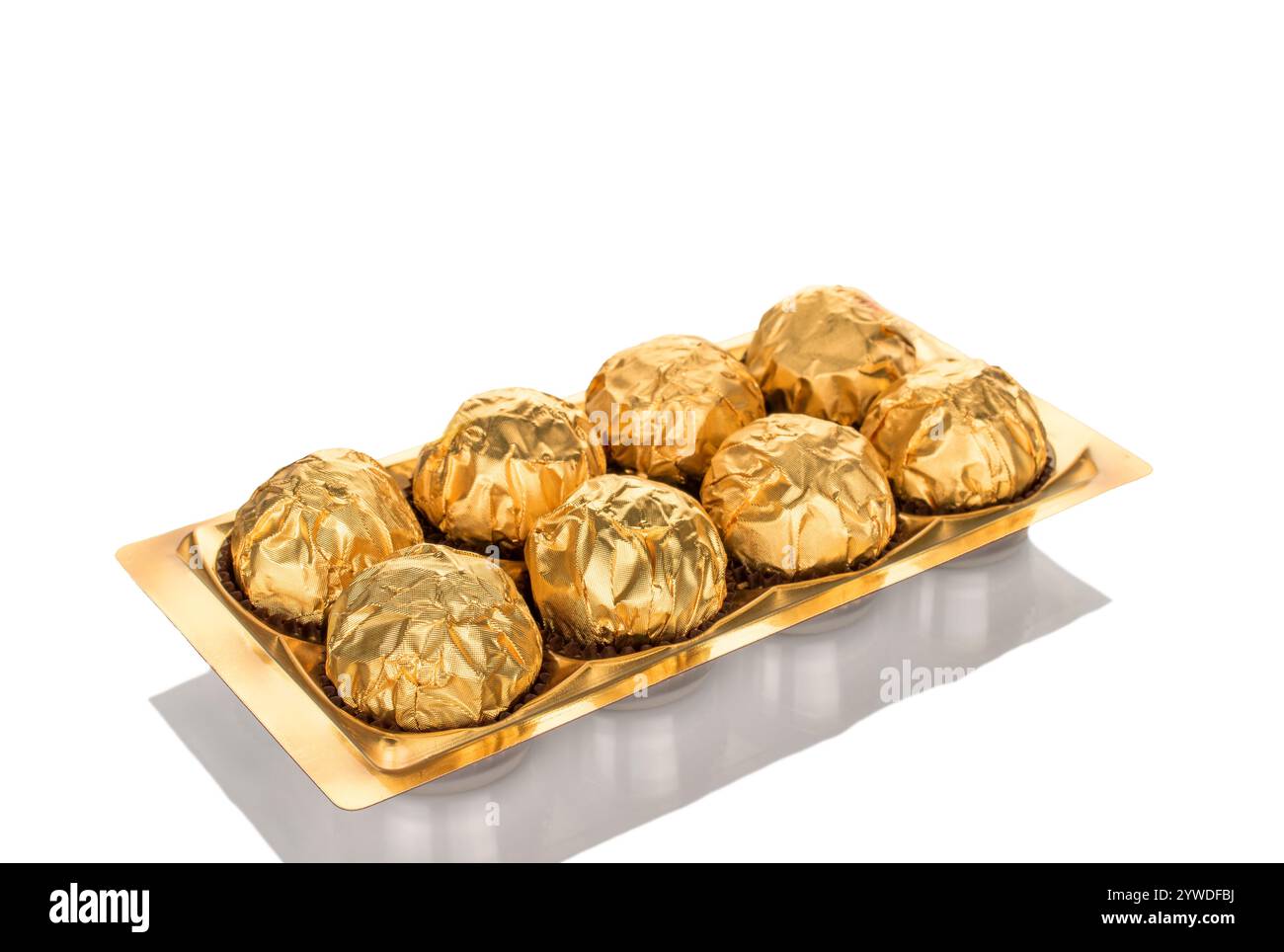 Diverse caramelle di cioccolato confezionate in carta regalo, primo piano, isolate su sfondo bianco. Foto Stock