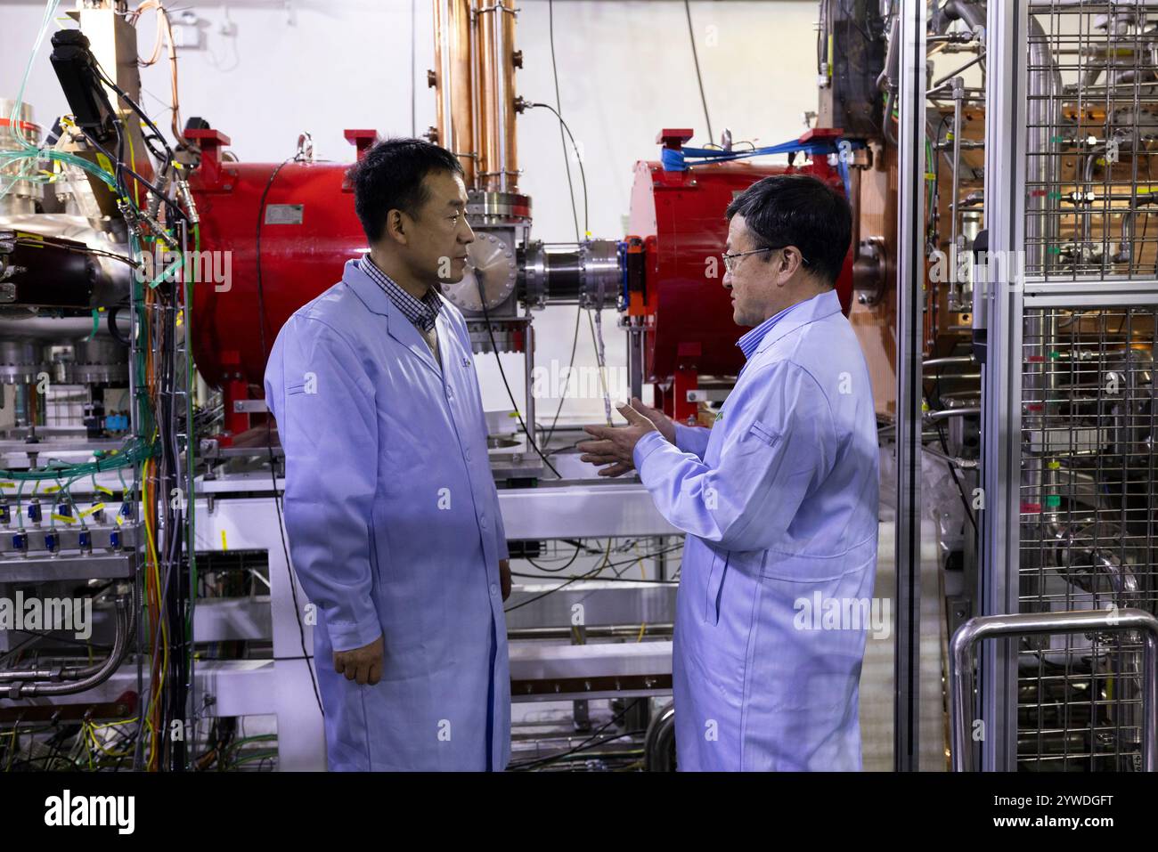 (241211) -- LANZHOU, 11 dicembre 2024 (Xinhua) -- Zhao Hongwei (R), un accademico della Chinese Academy of Sciences (CAS), e Sun Liangting, un ricercatore presso l'Institute of Modern Physics of the CAS, discutono sui progressi degli esperimenti di fronte alla struttura a basso consumo di ioni pesanti ad alta intensità (LEAF) il 10 dicembre 2024. La prima struttura al mondo a basso consumo energetico e ad alta intensità di acceleratore di ioni pesanti (LEAF), sviluppata dall'Institute of Modern Physics dell'Accademia cinese delle scienze, ha recentemente superato l'ispezione di accettazione del gruppo di esperti organizzata dal National Natural SC Foto Stock