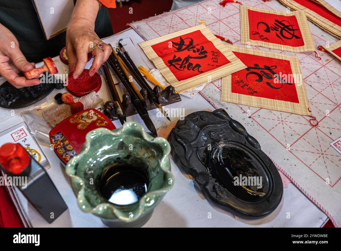Vietnam, Hanoi, 2024-02-14, Tet festival, Capodanno cinese, calligrafia, sigillo rosso calligrafico, inchiostro cinese, spazzola, tradizione, carta rossa, arte Foto Stock