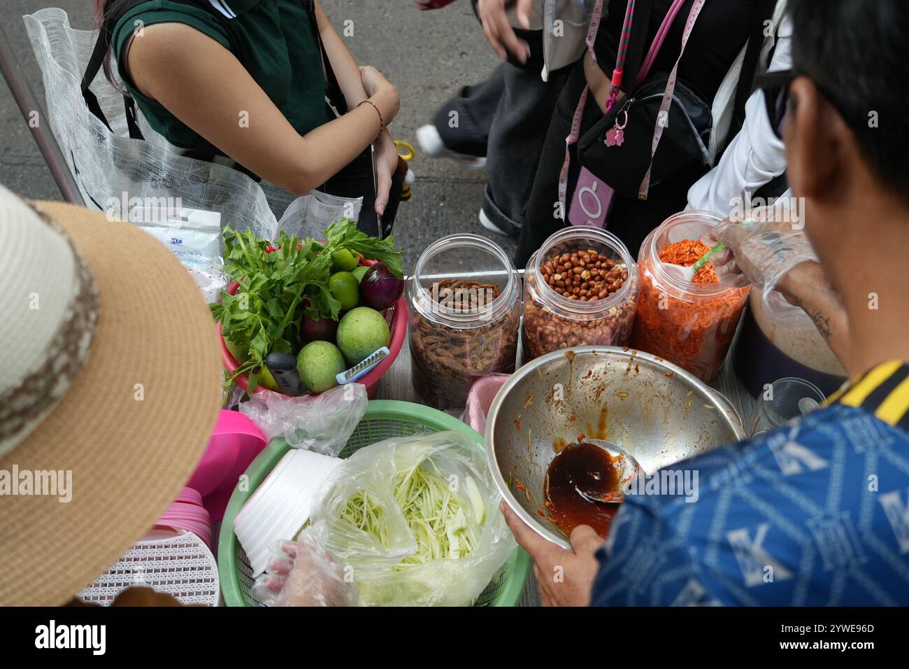 Cibo di strada a bangkok. Il fornitore di cibo prepara l'insalata Som Tam al mercato alimentare notturno. Mescolando mango o papaya e spezie, piccanti e aspri Foto Stock