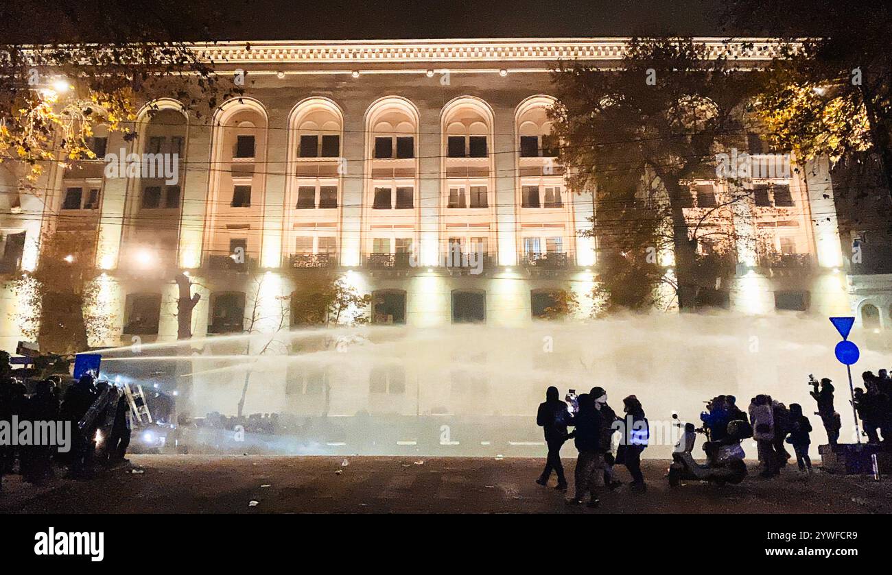 Tbilisi, Georgia - 1 dicembre 2024: Le forze speciali della polizia camminano in inseguimento per strada i manifestanti che protestano per l'UE in Rustaveli avenue. Unio europeo Foto Stock