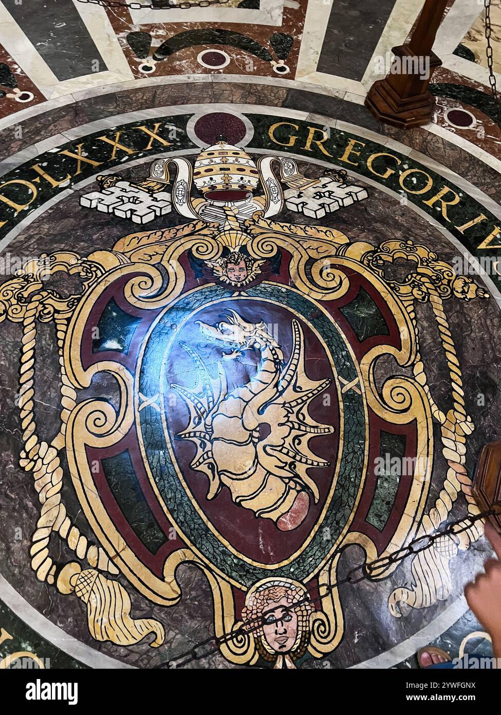 Città del Vaticano, Vaticano - 20 luglio 2022: L'immagine cattura un mosaico decorato a pavimento con un emblema del drago e simboli papali, mostrando intricati elementi artistici Foto Stock