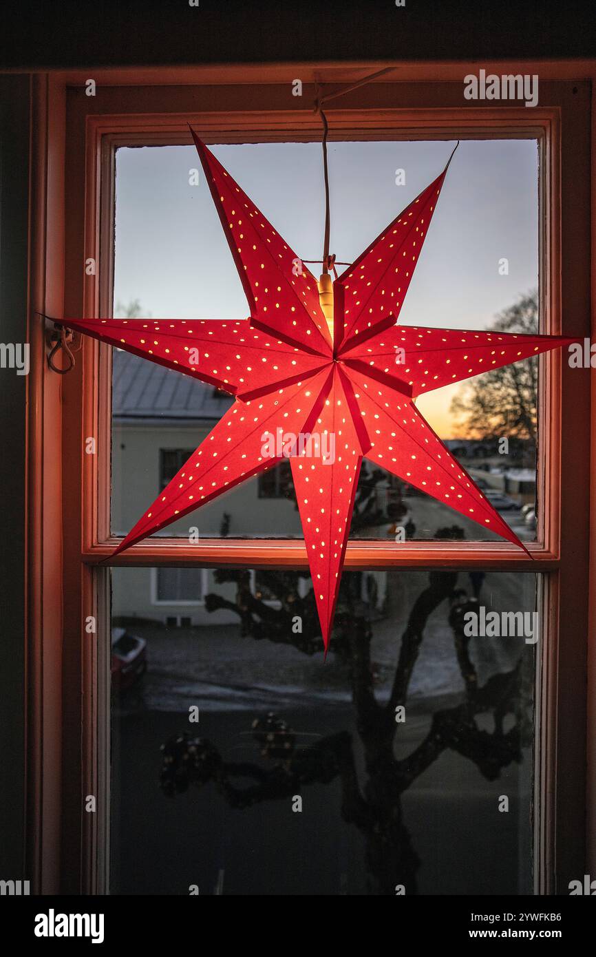 Decorazioni natalizie elettriche della stella dell'Avvento in finestra con neve all'aperto nel pomeriggio in svezia Foto Stock