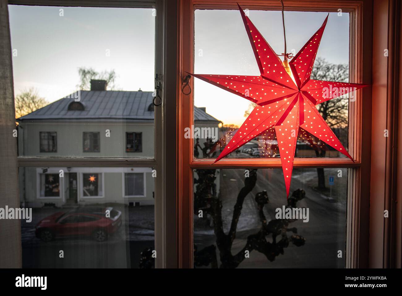 Decorazioni natalizie elettriche della stella dell'Avvento in finestra con neve all'aperto nel pomeriggio in svezia Foto Stock