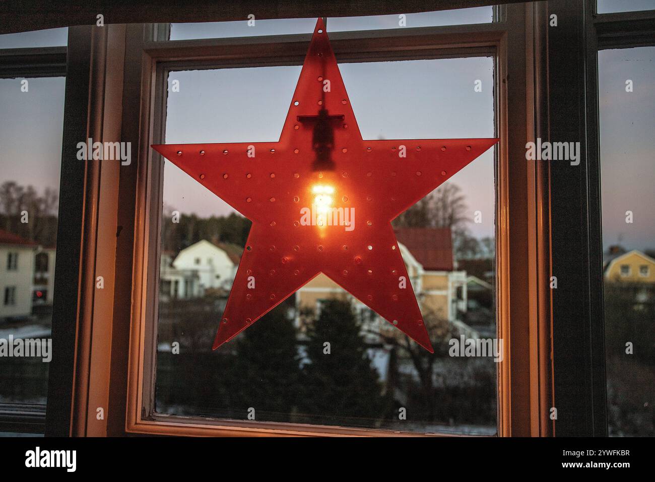 Decorazioni natalizie elettriche della stella dell'Avvento in finestra con neve all'aperto nel pomeriggio in svezia Foto Stock