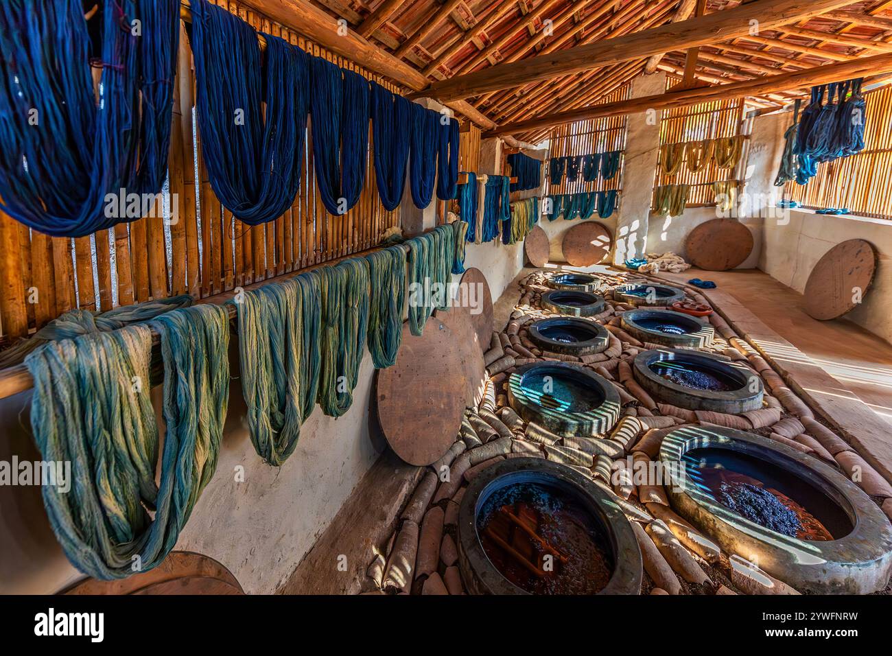 Laboratorio con serbatoi di coloranti indaco e fili tinti indaco a Gujarat, India Foto Stock