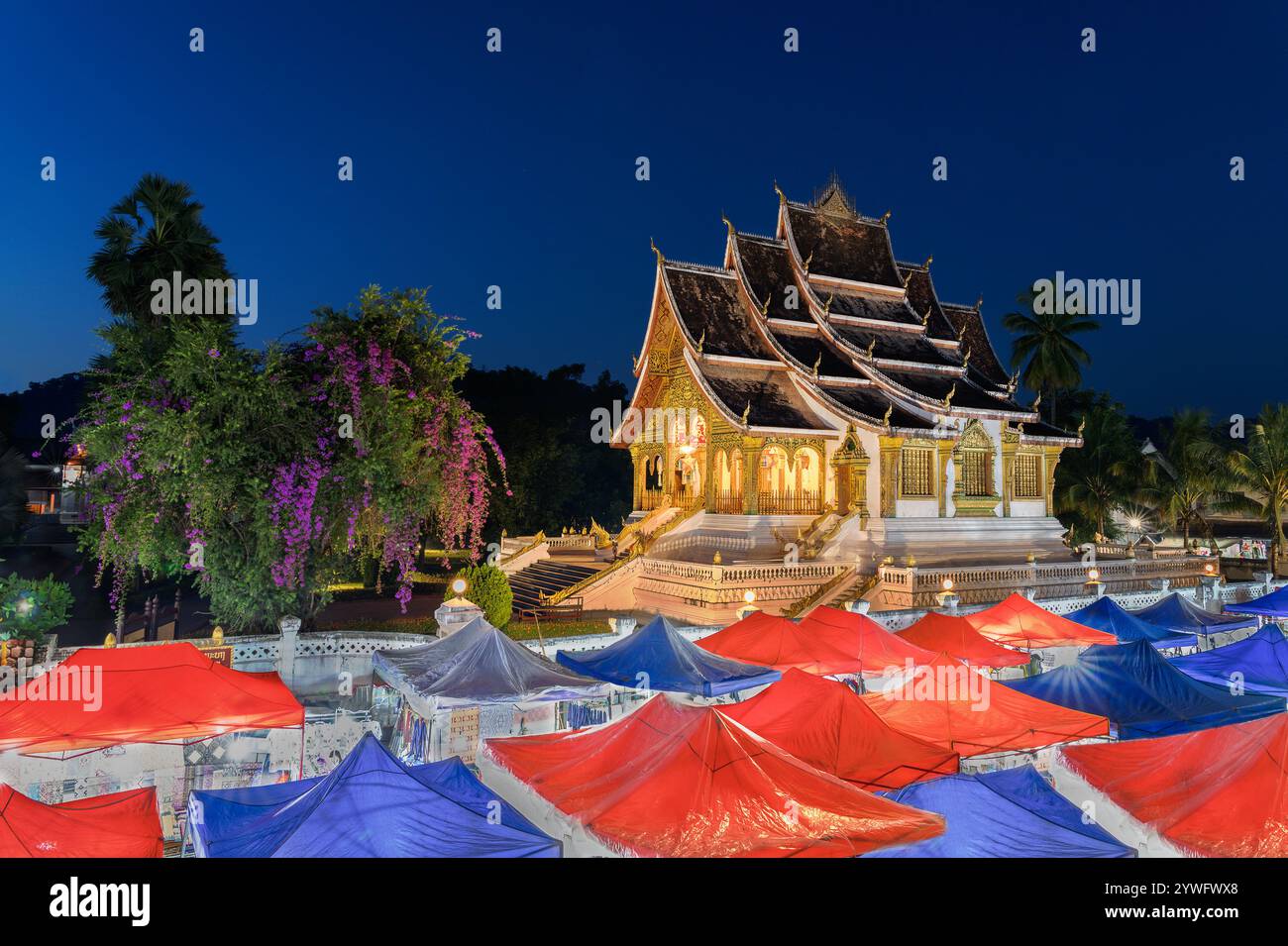 Mercato notturno a Luang Prabang con il palazzo reale di Luang Prabang, noto anche come museo nazionale di Luang Prabang sullo sfondo, il Laos Foto Stock