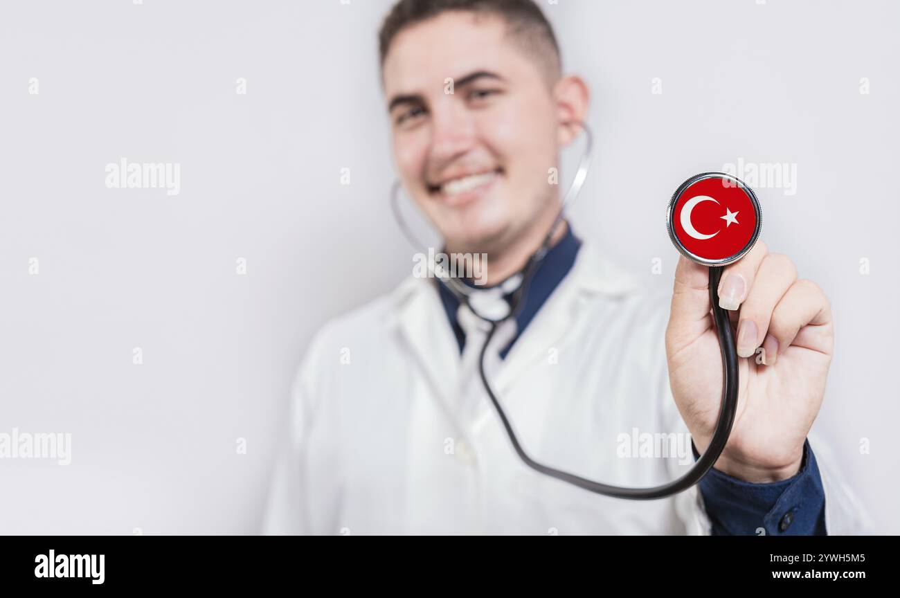 Medico sorridente che mostra lo stetoscopio con la bandiera di tacchino. Concetto sanitario nazionale della Turchia Foto Stock