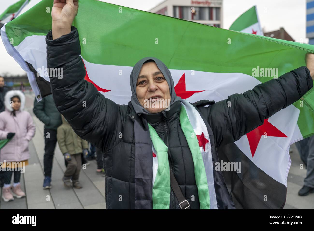 La donna siriana celebra la fine del regime di Assad dopo il cambio di potere in Siria in un raduno sulla piazza di fronte alla stazione ferroviaria principale di Foto Stock