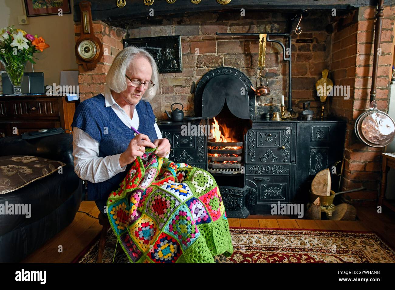 Lady Crocheting davanti alle sue famiglie Coalbrookdale ghisa Victorian Fire Cooking Range Foto Stock