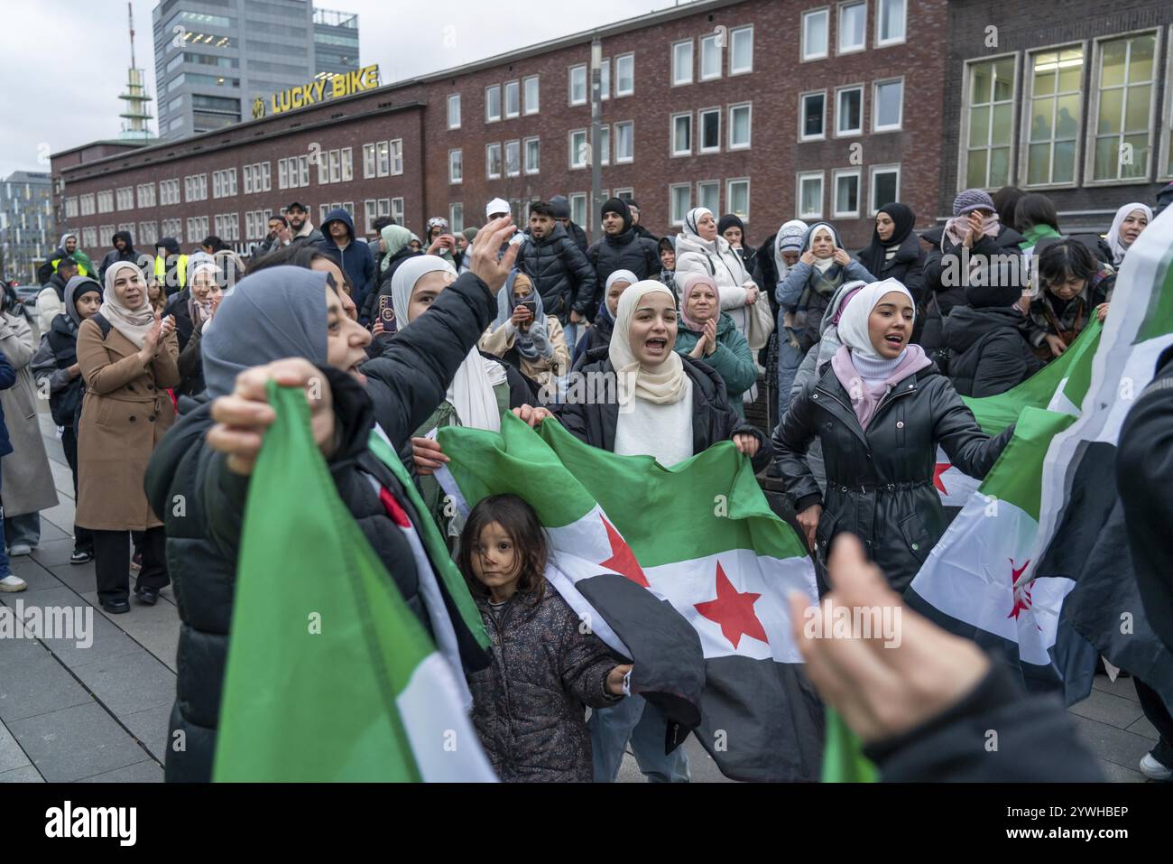 La donna siriana celebra la fine del regime di Assad dopo il cambio di potere in Siria in un raduno sulla piazza di fronte alla stazione ferroviaria principale di Foto Stock