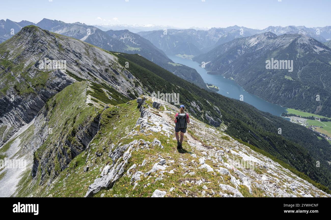 Alpinista sulla cresta sommitale dell'Unnuetz, dietro l'Achensee e cima dell'incrocio Seekarspitze Unnuetz, Alpi Brandenberg, Tirolo, Austria, EUR Foto Stock