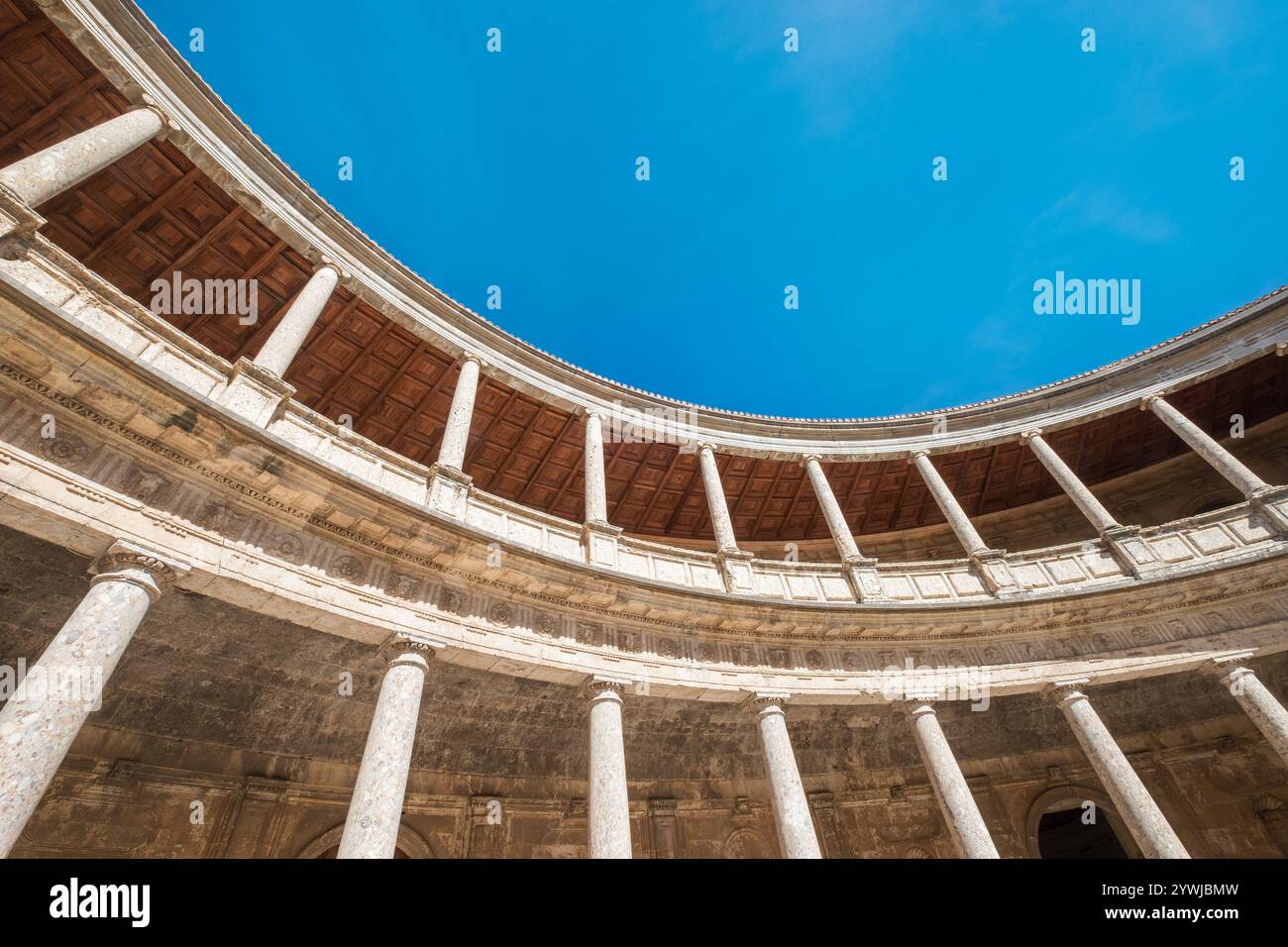 Incredibile vista grandangolare delle gallerie con colonne nel patio circolare interno del Palazzo di Carlo V nel complesso Alhambra a Granada, Andalusia, Spa Foto Stock