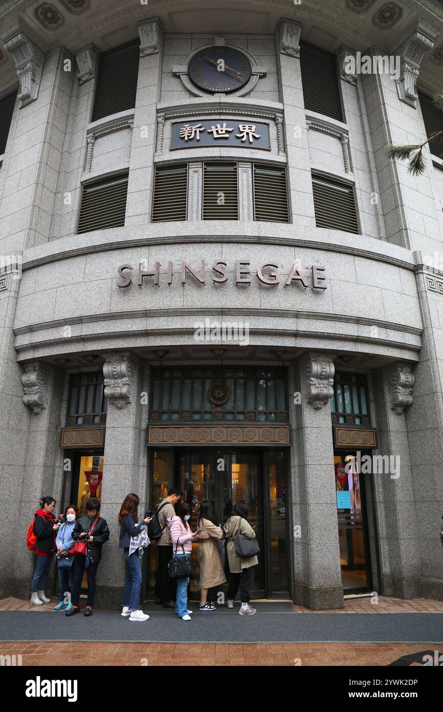 SEOUL, COREA DEL SUD - 6 APRILE 2023: La gente aspetta l'apertura del grande magazzino Shinsegae nel quartiere dello shopping di Myeongdong a Seoul di notte. Foto Stock