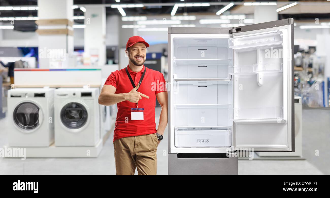 Direttore del negozio che si appoggia su un frigorifero e punta Foto Stock