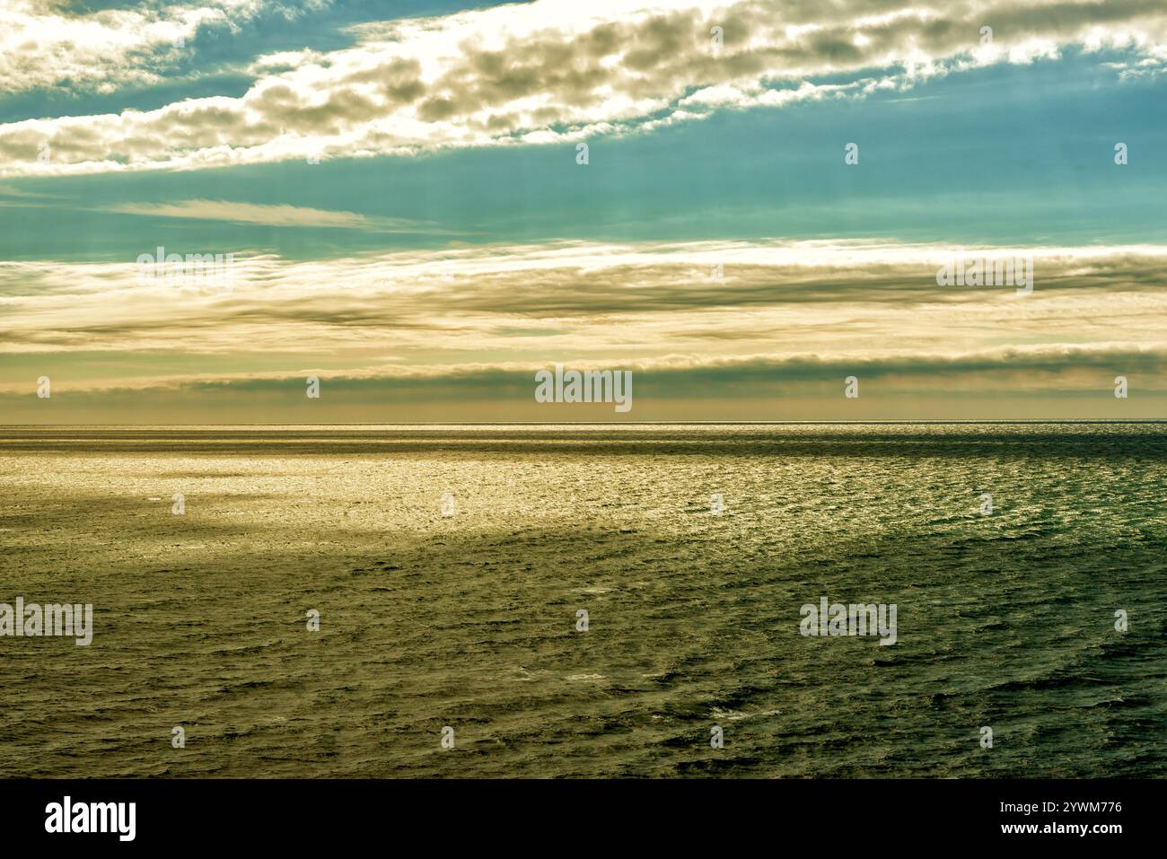 Vista sul mare con un punto luminoso sull'acqua e splendide nuvole Foto Stock