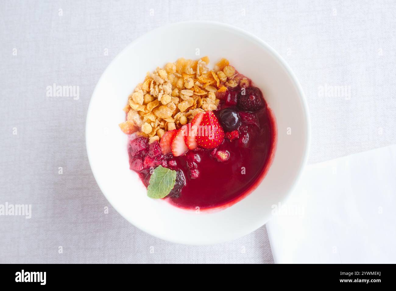 Una ciotola di acai fresca su una tovaglia bianca - colazione sana ed elegante. Foto Stock