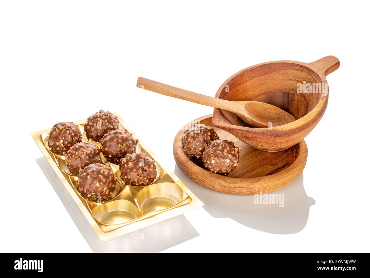 Caramelle al cioccolato con nocciole in una ciotola di legno, primo piano, isolate su sfondo bianco. Foto Stock