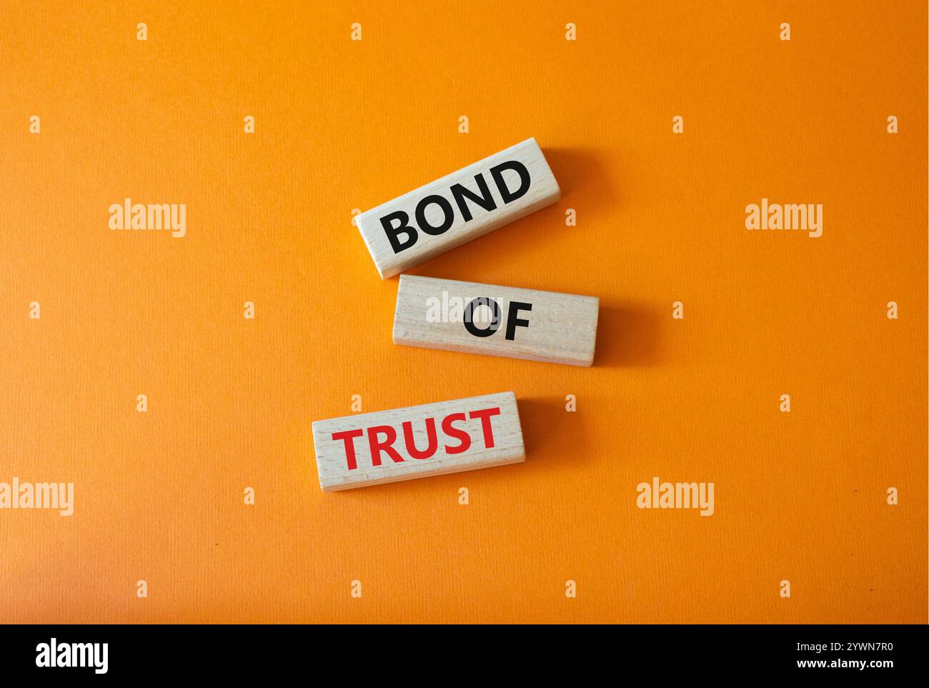 Simbolo del legame di fiducia. Blocchi di legno con parole Bond of Trust. Bellissimo sfondo arancione. Business e Bond of Trust. Copia spazio. Foto Stock