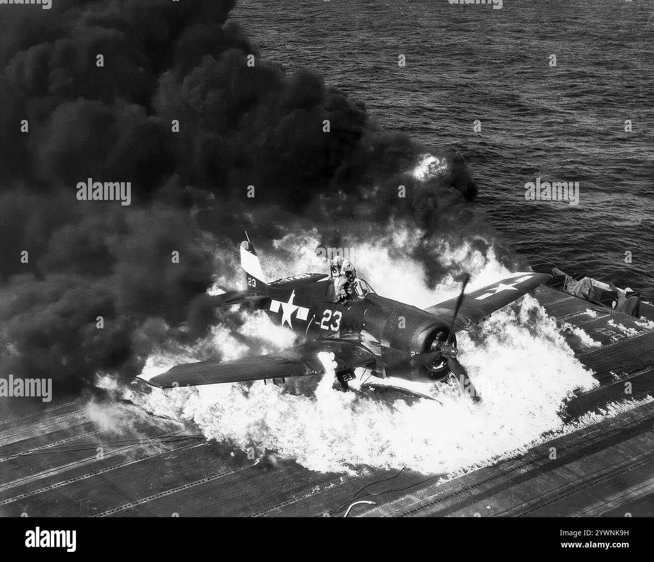 Un Grumman F6F Hellcat si è schiantato bruciando sul ponte di volo di in mare al largo della portaerei USS Lexington. L'aereo da caccia americano basato sulle portaerei della seconda guerra mondiale ha fatto il suo debutto in combattimento nel settembre 1943 e successivamente si è affermato come un caccia da portaerei robusto e ben progettato. Divenne il combattente dominante della Marina degli Stati Uniti nella seconda metà della guerra del Pacifico. In totale, 12.275 furono costruiti in poco più di due anni e alla Hellcats fu attribuito il merito di aver distrutto un totale di 5.223 aerei nemici mentre era in servizio con la Marina degli Stati Uniti, il corpo dei Marines e la Royal Navy Fleet Air Arm (FAA). Foto Stock