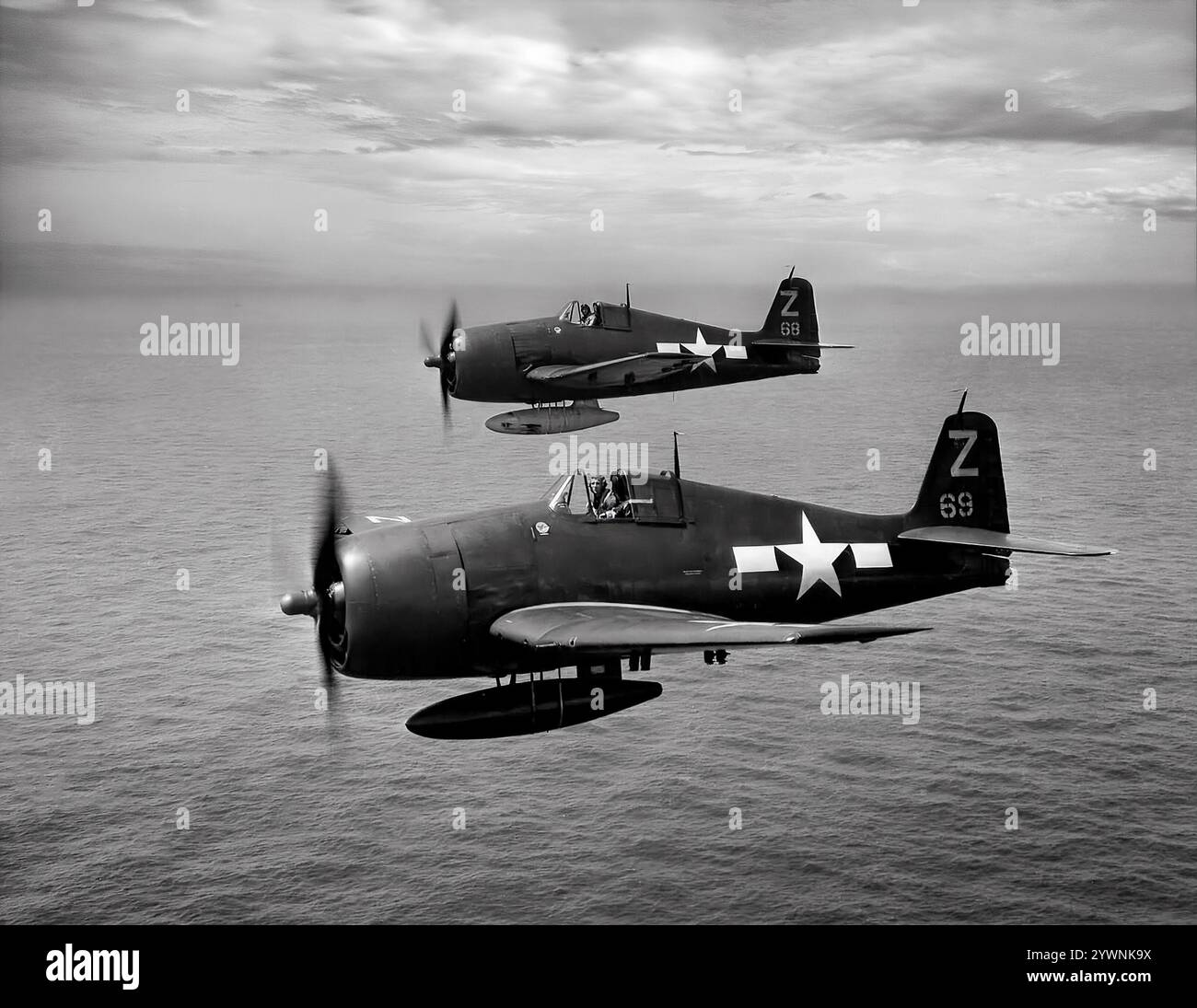 Due Grumman F6F Hellcats al largo della USS Shangri-la in volo vicino al Giappone nell'agosto 1945. L'aereo da caccia americano basato sulle portaerei della seconda guerra mondiale ha fatto il suo debutto in combattimento nel settembre 1943 e successivamente si è affermato come un caccia da portaerei robusto e ben progettato. Divenne il combattente dominante della Marina degli Stati Uniti nella seconda metà della guerra del Pacifico. In totale, 12.275 furono costruiti in poco più di due anni e alla Hellcats fu attribuito il merito di aver distrutto un totale di 5.223 aerei nemici mentre era in servizio con la Marina degli Stati Uniti, il corpo dei Marines e la Royal Navy Fleet Air Arm (FAA). Foto Stock