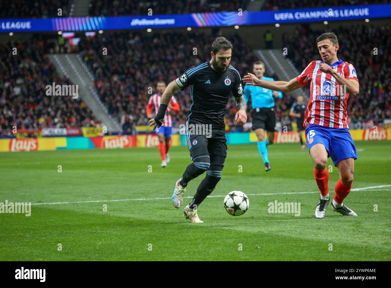 Madrid, Spagna, 11 dicembre 2024: Tigran Barseghyan (11, L) di Slovan Bratislava passa la palla davanti a Clément Lenglet (15, R) durante la partita del sesto turno di UEFA Champions League 2024-25 tra l'Atletico de Madrid e Slovan Bratislava l'11 dicembre 2024 allo Stadio Riyadh Air Metropolitano di Madrid, Spagna. Crediti: Alberto Brevers / Alamy Live News. Foto Stock