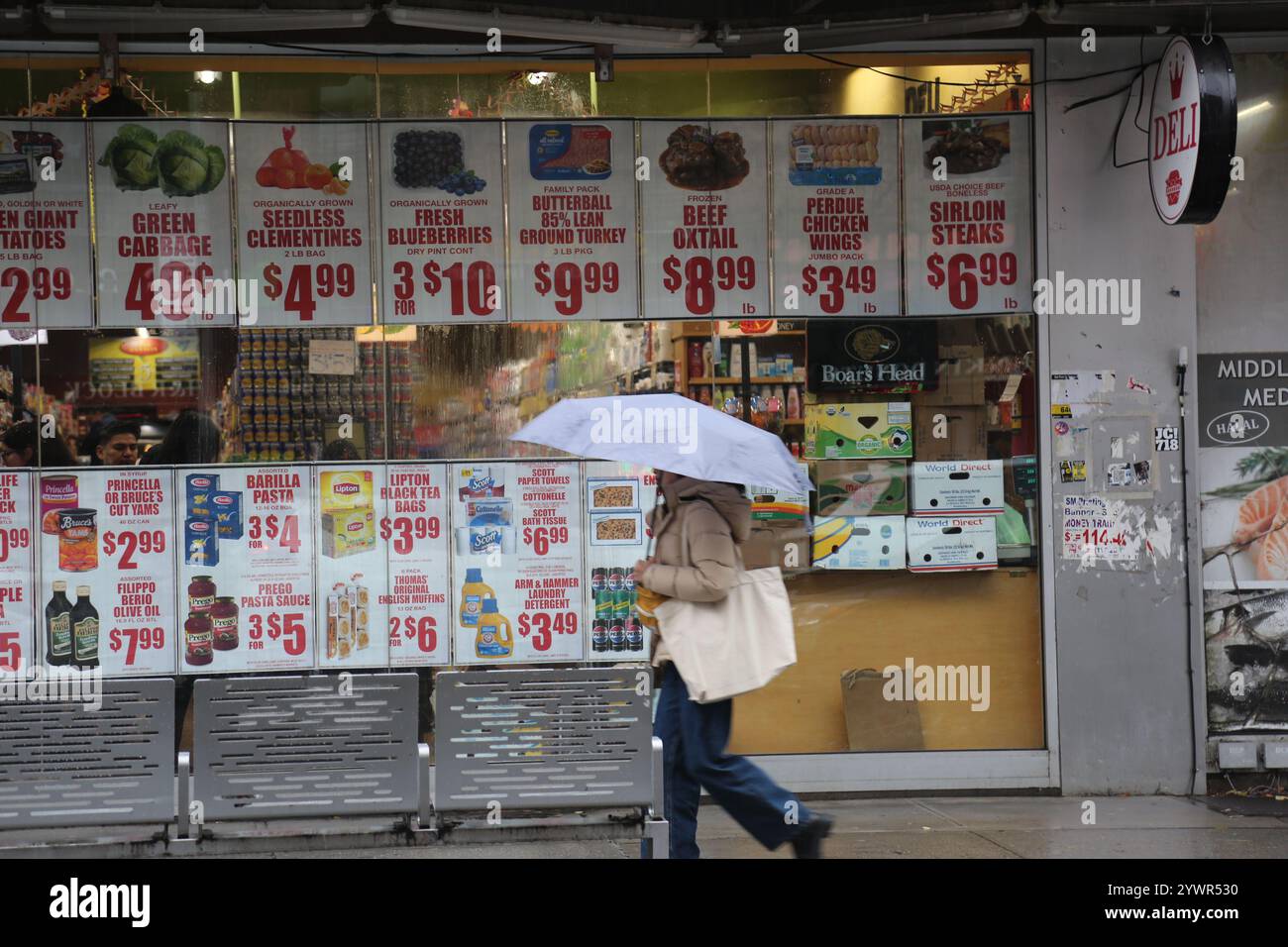 New York, Stati Uniti. 11 dicembre 2024. Un pedone passeggia davanti a un negozio di alimentari a New York, negli Stati Uniti, l'11 dicembre 2024. L'inflazione al consumo negli Stati Uniti a novembre è aumentata del 2,7% rispetto a un anno fa, dopo aver salito del 2,4% a settembre e del 2,6% a ottobre, il Dipartimento del lavoro degli Stati Uniti ha riferito mercoledì. Credito: Liu Yanan/Xinhua/Alamy Live News Foto Stock