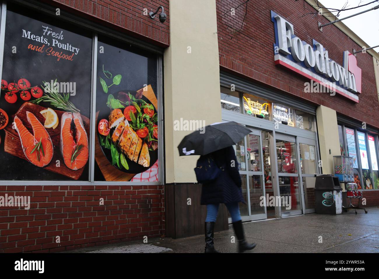 New York, Stati Uniti. 11 dicembre 2024. Un pedone passeggia davanti a un negozio di alimentari a New York, negli Stati Uniti, l'11 dicembre 2024. L'inflazione al consumo negli Stati Uniti a novembre è aumentata del 2,7% rispetto a un anno fa, dopo aver salito del 2,4% a settembre e del 2,6% a ottobre, il Dipartimento del lavoro degli Stati Uniti ha riferito mercoledì. Credito: Liu Yanan/Xinhua/Alamy Live News Foto Stock