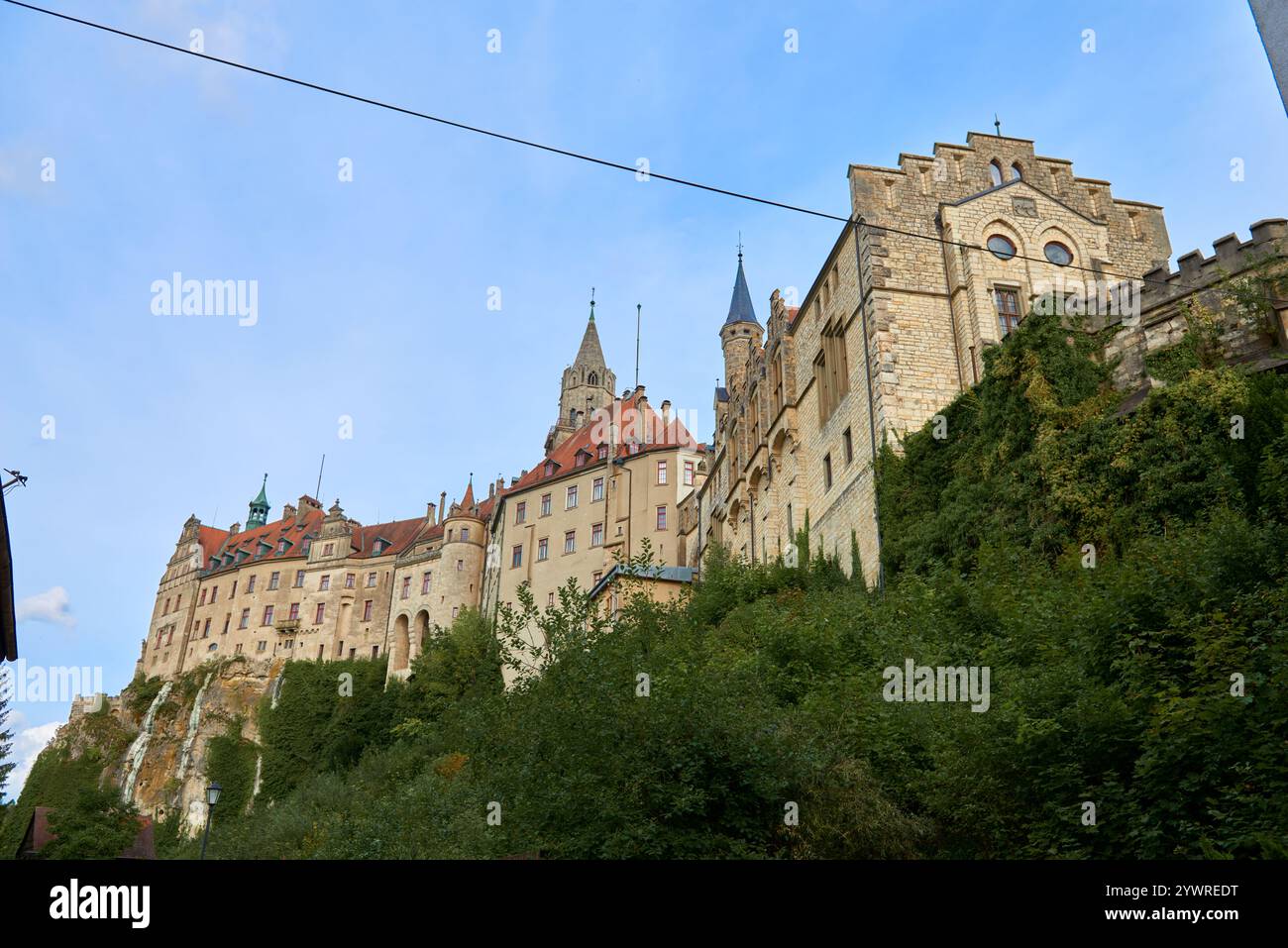 Maestoso castello di Sigmaringen arroccato su una scogliera rocciosa sopra il tranquillo Danubio: La storica residenza Hohenzollern presenta architettura medievale e il Palazzo reale Foto Stock