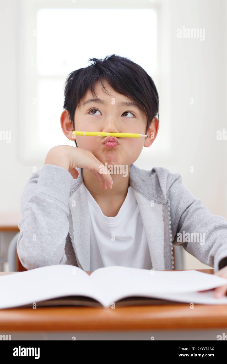 Ragazzo che pensa con la matita sotto il naso Foto Stock