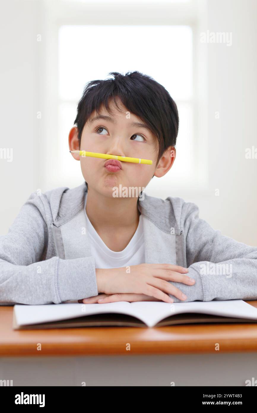 Ragazzo che pensa con la matita sotto il naso Foto Stock