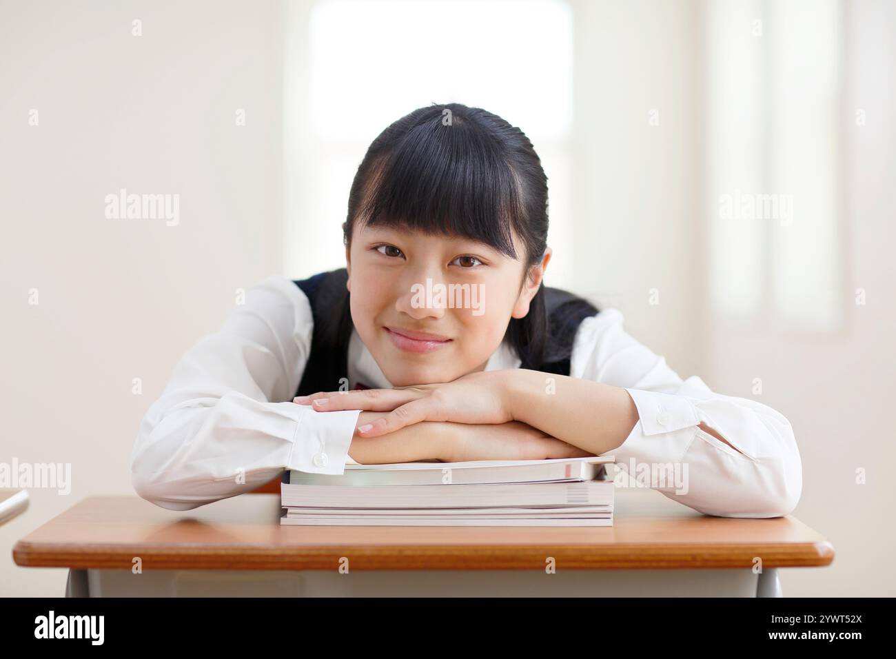 Ragazza in uniforme scolastica che si rilassa in classe Foto Stock