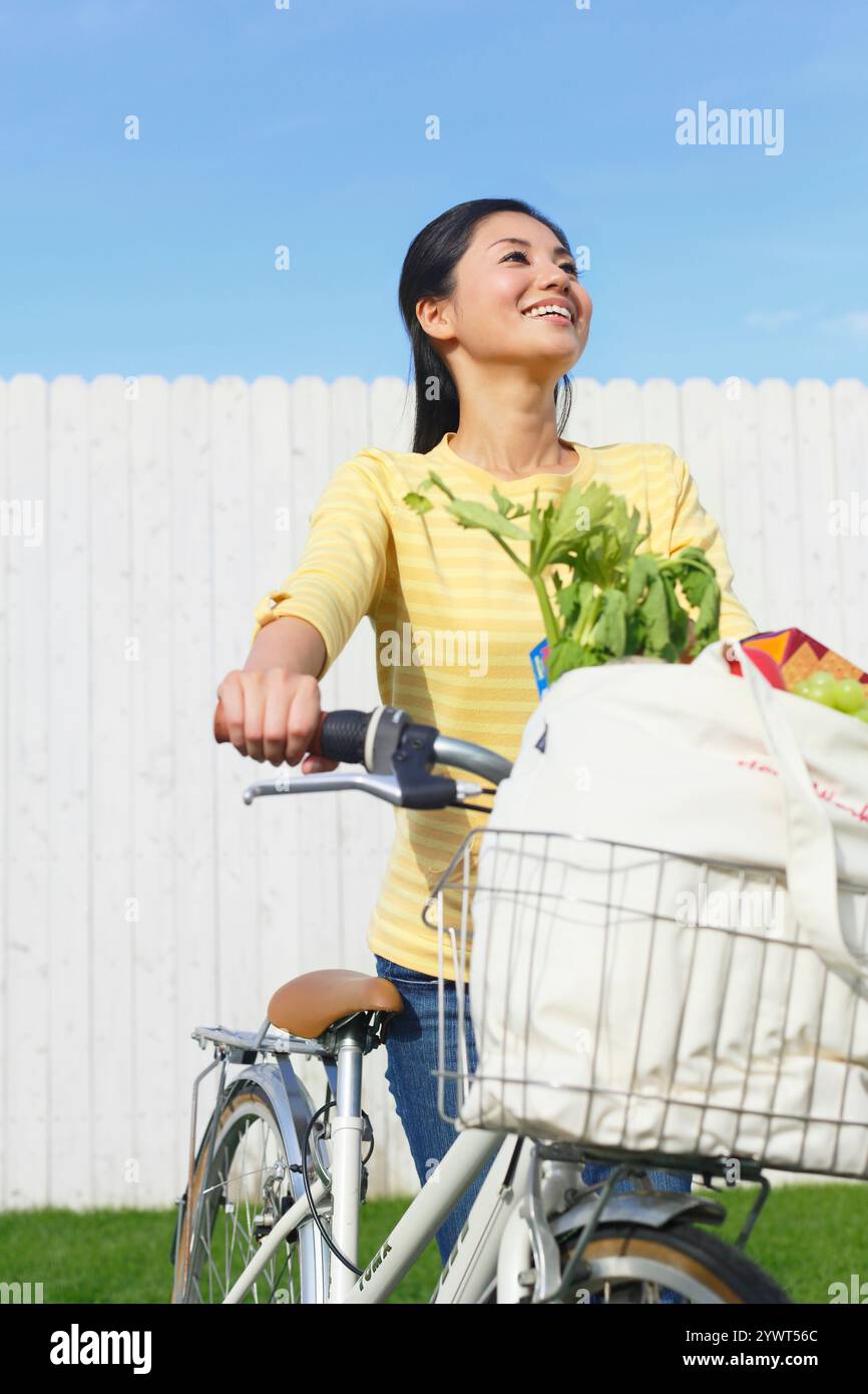 Donna fuori a fare shopping in bicicletta Foto Stock