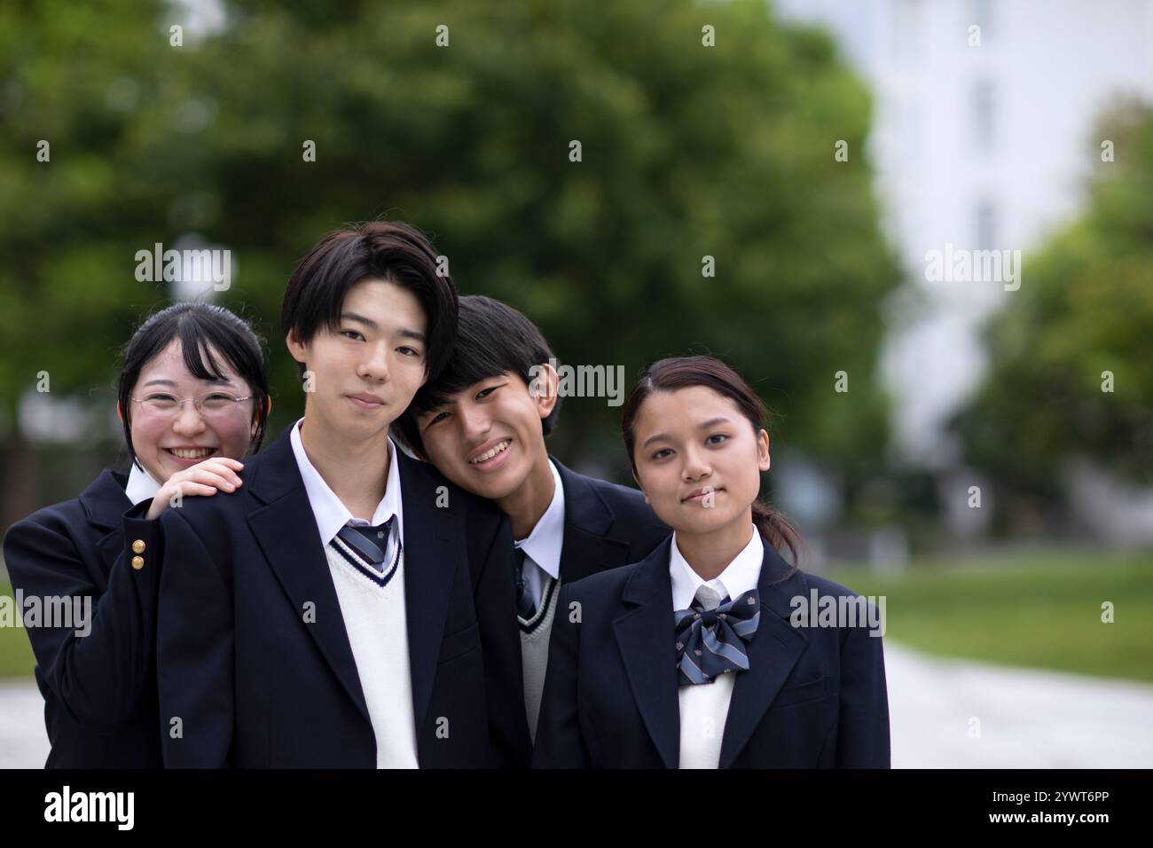 Studenti delle scuole superiori che guardano la macchina fotografica con gli amici Foto Stock