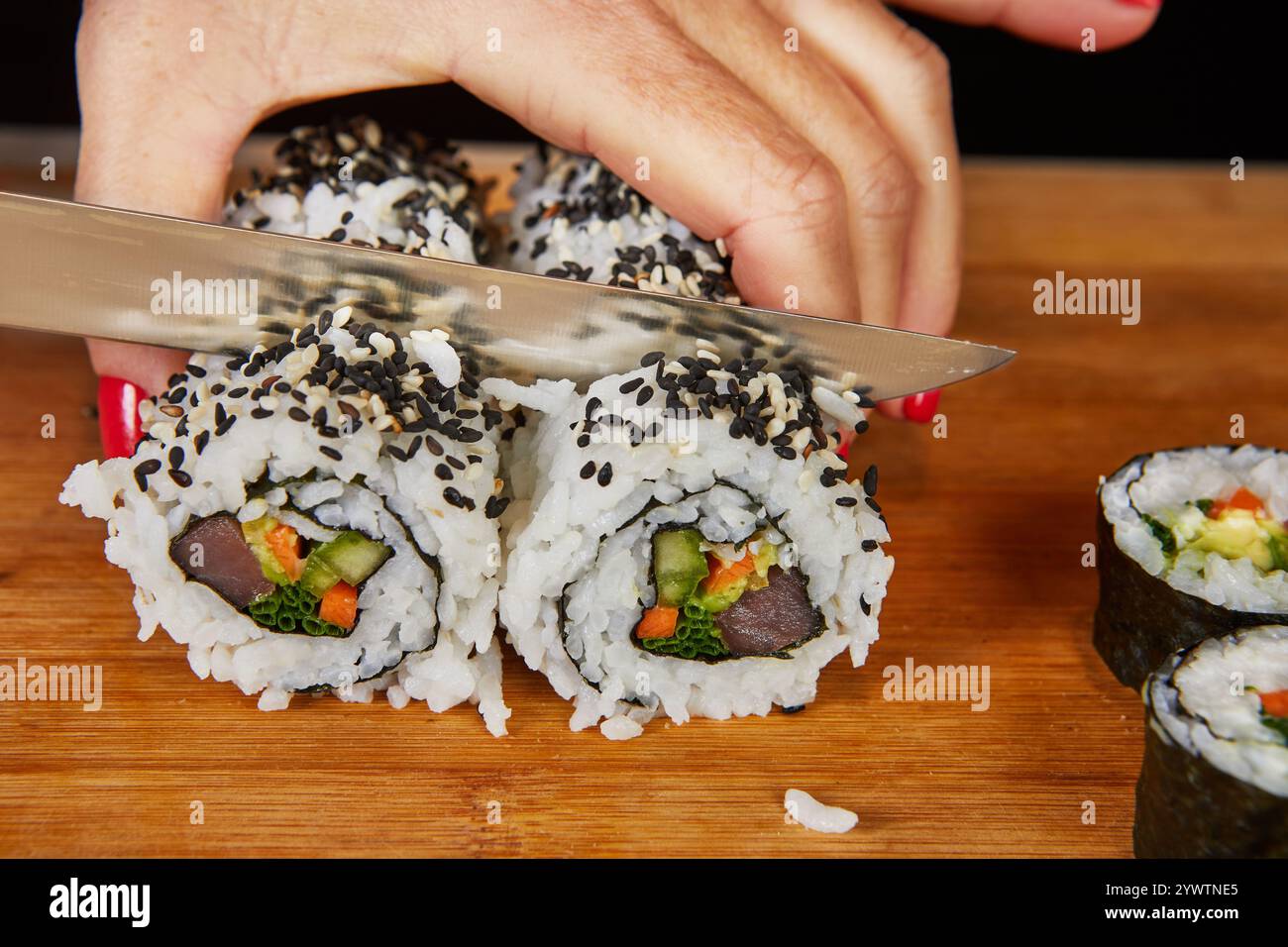 Un variegato assortimento di sushi Rolls serviti su piatti eleganti con salsa di soia e bacchette, creando una vivace scena culinaria giapponese. Foto Stock