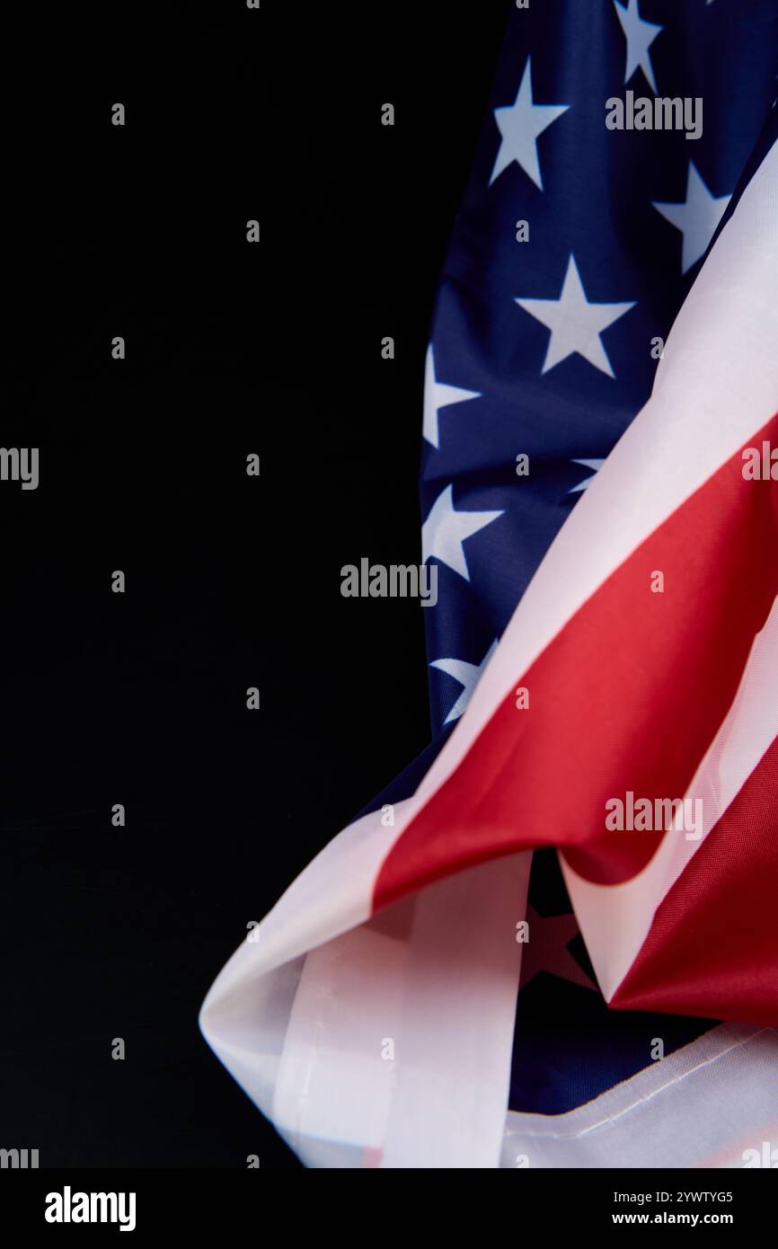 Una vista dettagliata della bandiera americana su uno sfondo scuro, caratterizzato dai suoi colori vivaci e dai motivi intricati Foto Stock