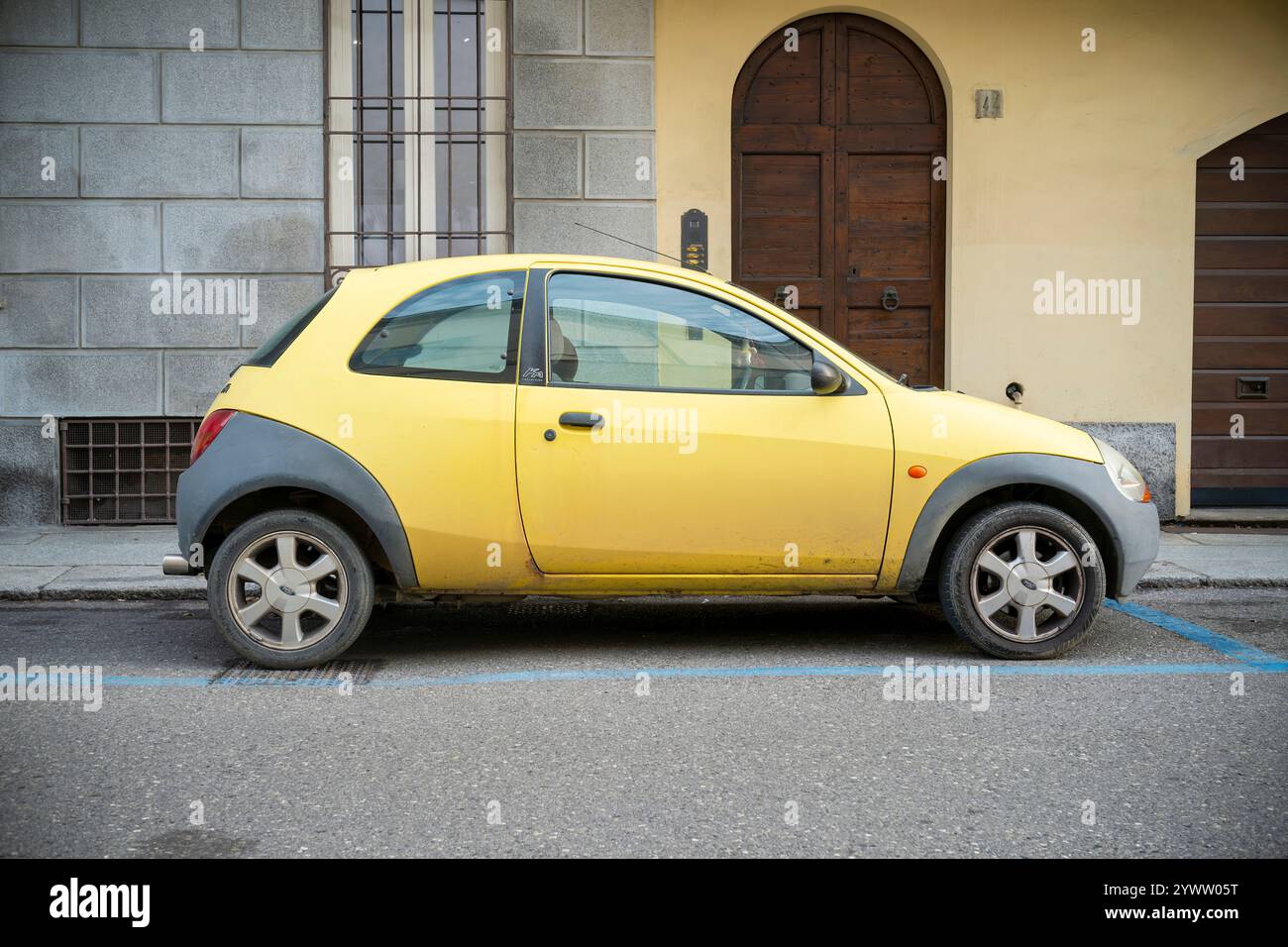 Cremona, Italia - 27 novembre 2024 una piccola ford ka gialla parcheggiata su una strada cittadina, che mette in mostra i parcheggi urbani e la presenza automobilistica Foto Stock