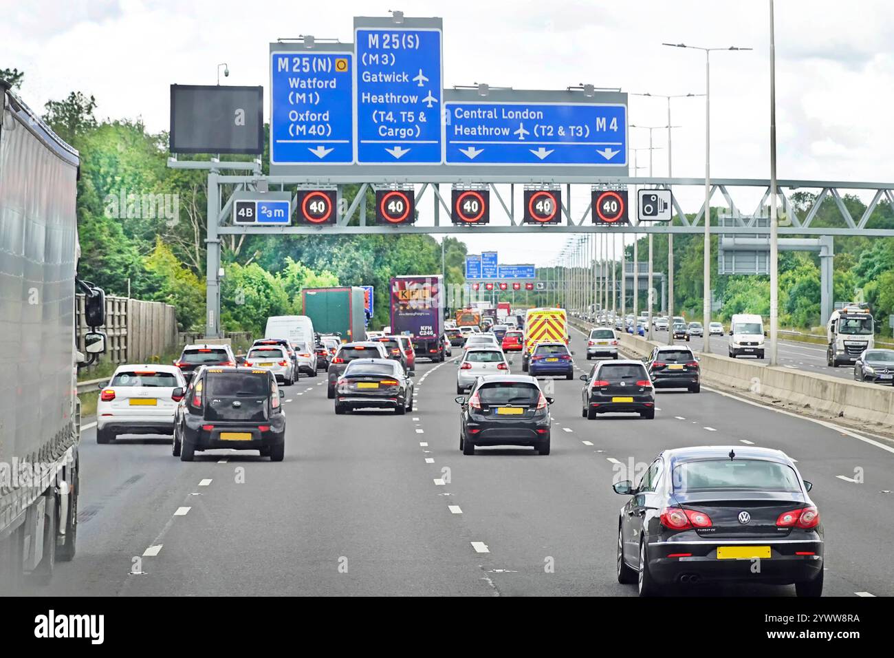 Autostrada M25 a cinque corsie trafficata allo svincolo 4B segnaletica di destinazione del gantry superiore al limite di velocità variabile elettronico di 40 km/h nelle ore di punta del venerdì, Londra sud, Regno Unito Foto Stock