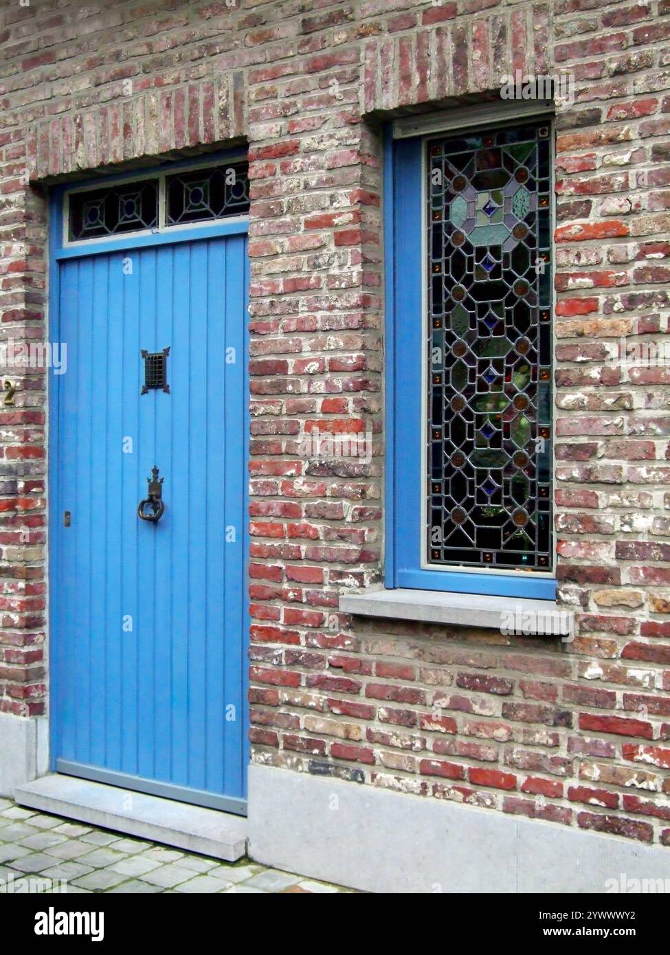 Pittoresca e pittoresca casa in mattoni con porta blu in una corsia o in una strada, Bruges, Belgio Foto Stock