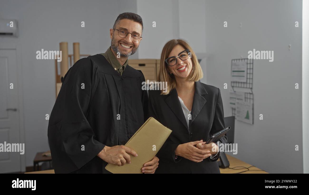 Uomo e donna in abiti da lavoro sorridenti in un ufficio di avvocati, in possesso di documenti, che indicano un ambiente legale professionale. Foto Stock