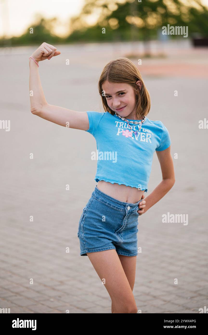 La ragazza molto felice che mostra le sue braccia forti. Foto Stock