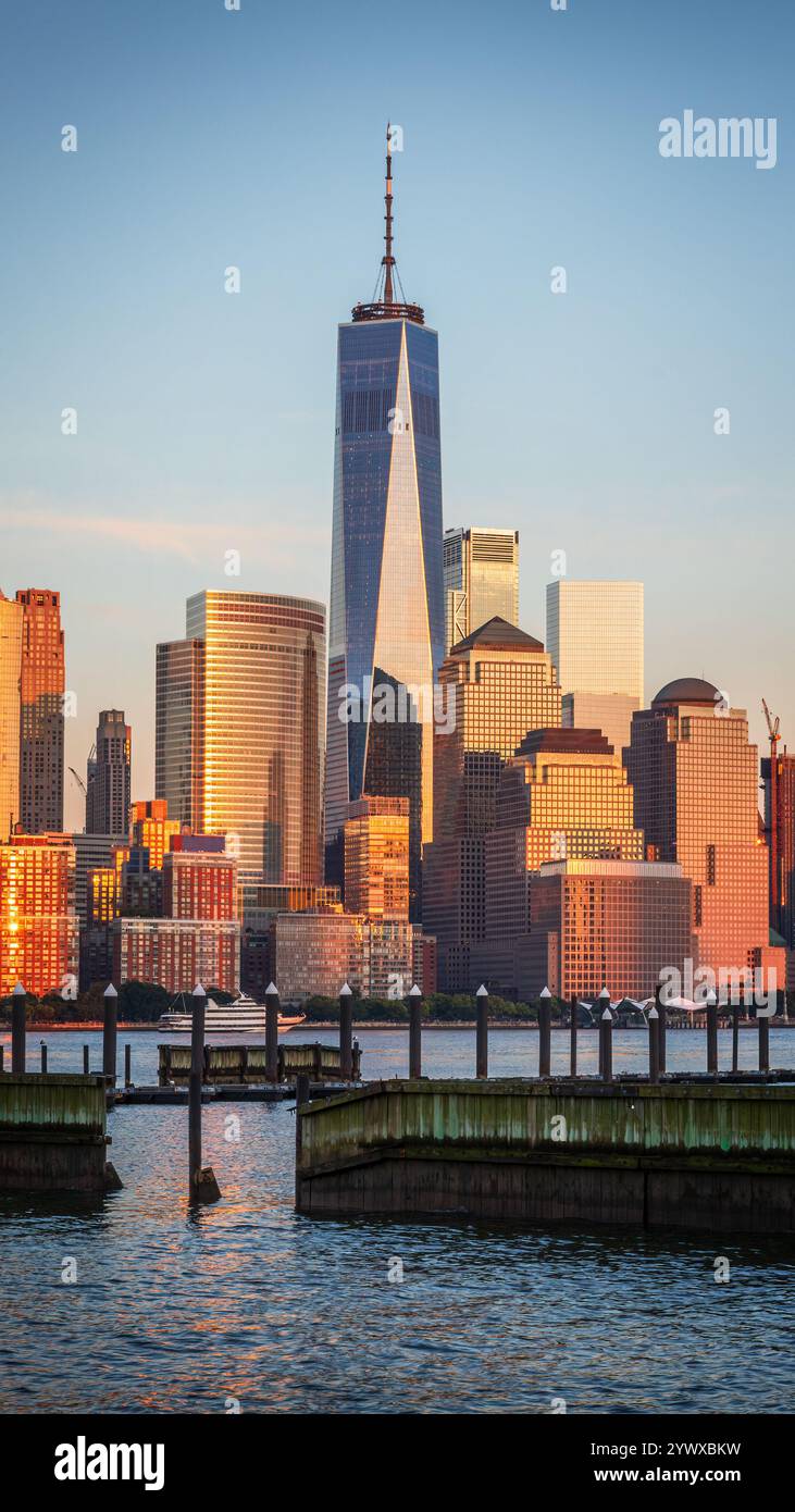 La foto cattura lo skyline di New York al tramonto, visto dal New Jersey. L'One World Trade Center si erge alto, riflettendo luce dorata, surrogato Foto Stock