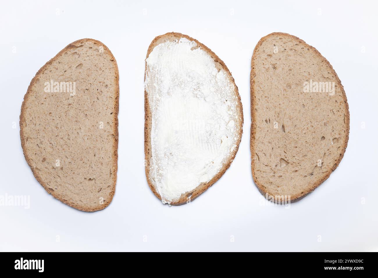 , Deutschland, 12.12.2024, Drei Brotscheiben, eine davon mit butter bestrichen, auf weißem Hintergrund. Perfekt für Ernährung und gesunde Essensideen Foto Stock