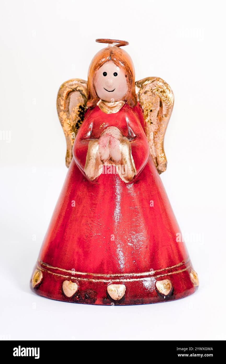 Angelo rosso in ceramica che prega e sorride su sfondo bianco. Foto Stock