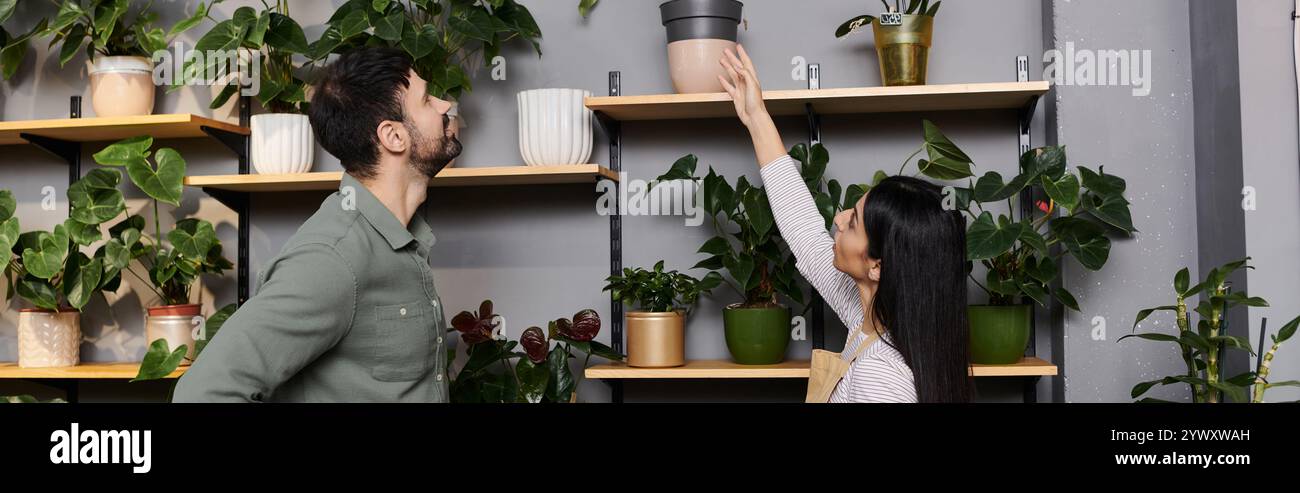 Un fiorista guida un cliente maschile attraverso una selezione di piante nel suo affascinante negozio, banner Foto Stock