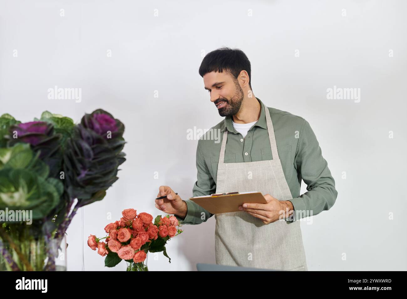 Un fiorista esperto organizza fiori vivaci mentre interagisce con i clienti nel suo negozio. Foto Stock