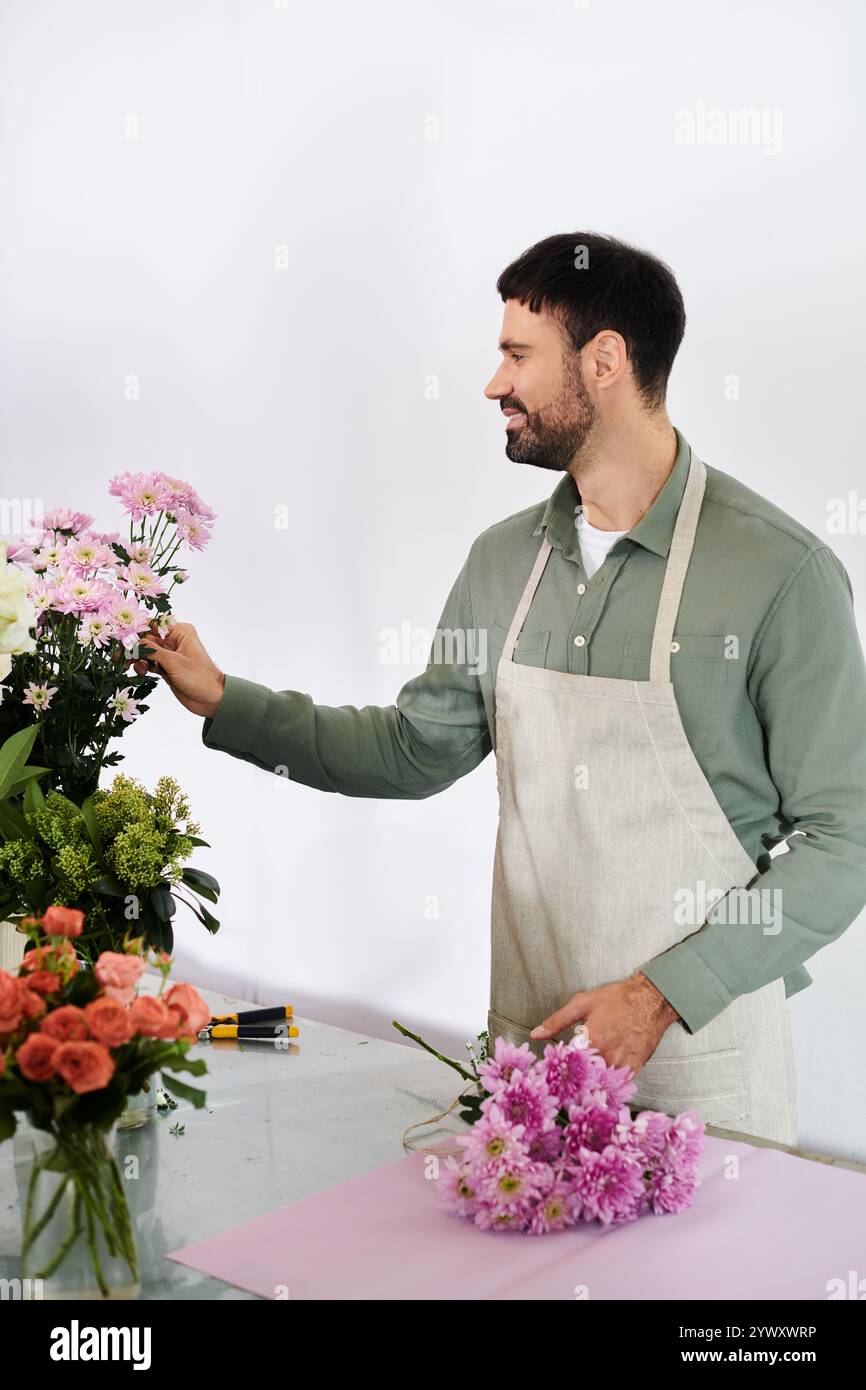 Un fiorista esperto organizza fiori freschi, mostrando la sua passione per la natura e la bellezza. Foto Stock